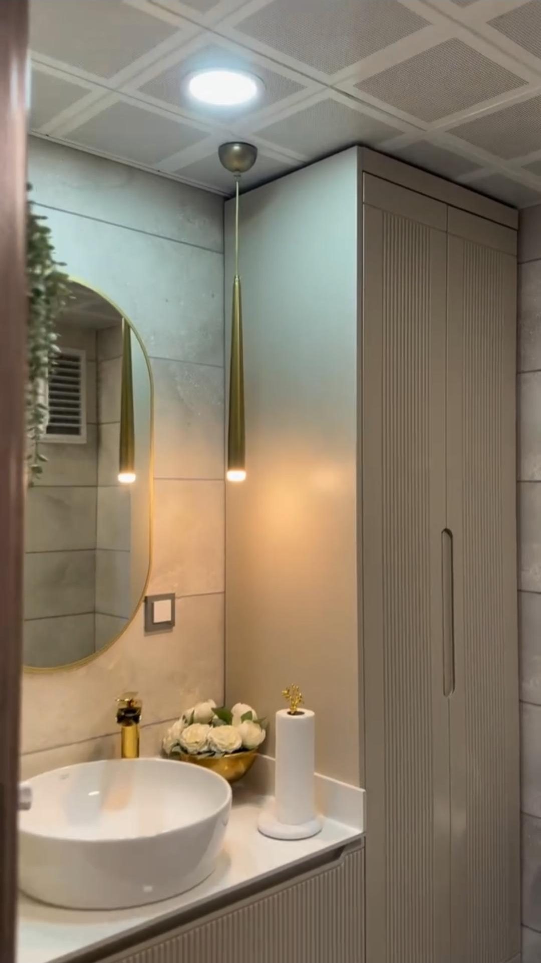 Kanallı krem lavabo dolabı, pirinç sarkıt aydınlatma ve oval ayna