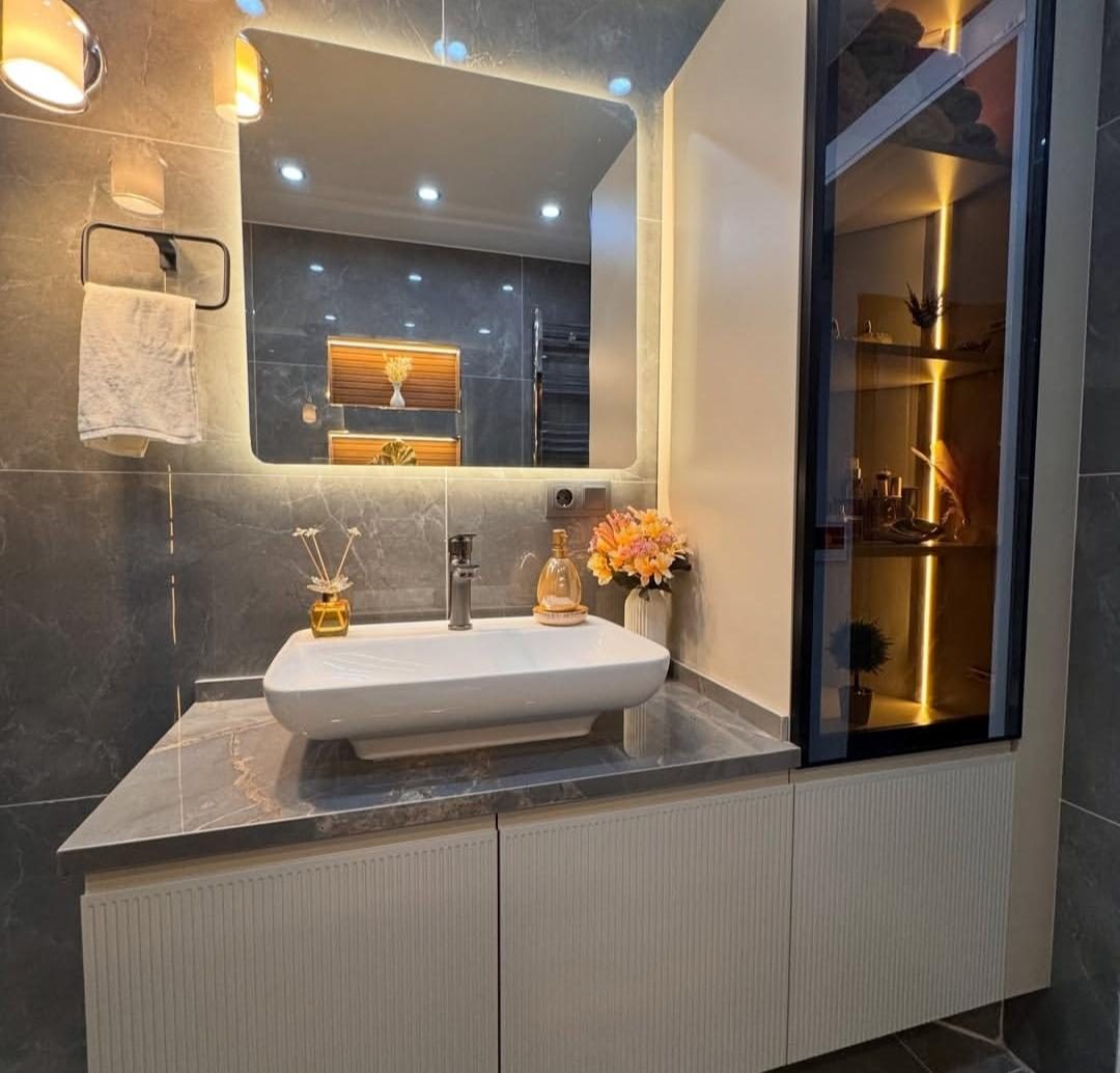 Kanallı beyaz lavabo dolabı, arkadan aydınlatmalı ayna ve siyah çerçeveli camlı vitrin kolonu